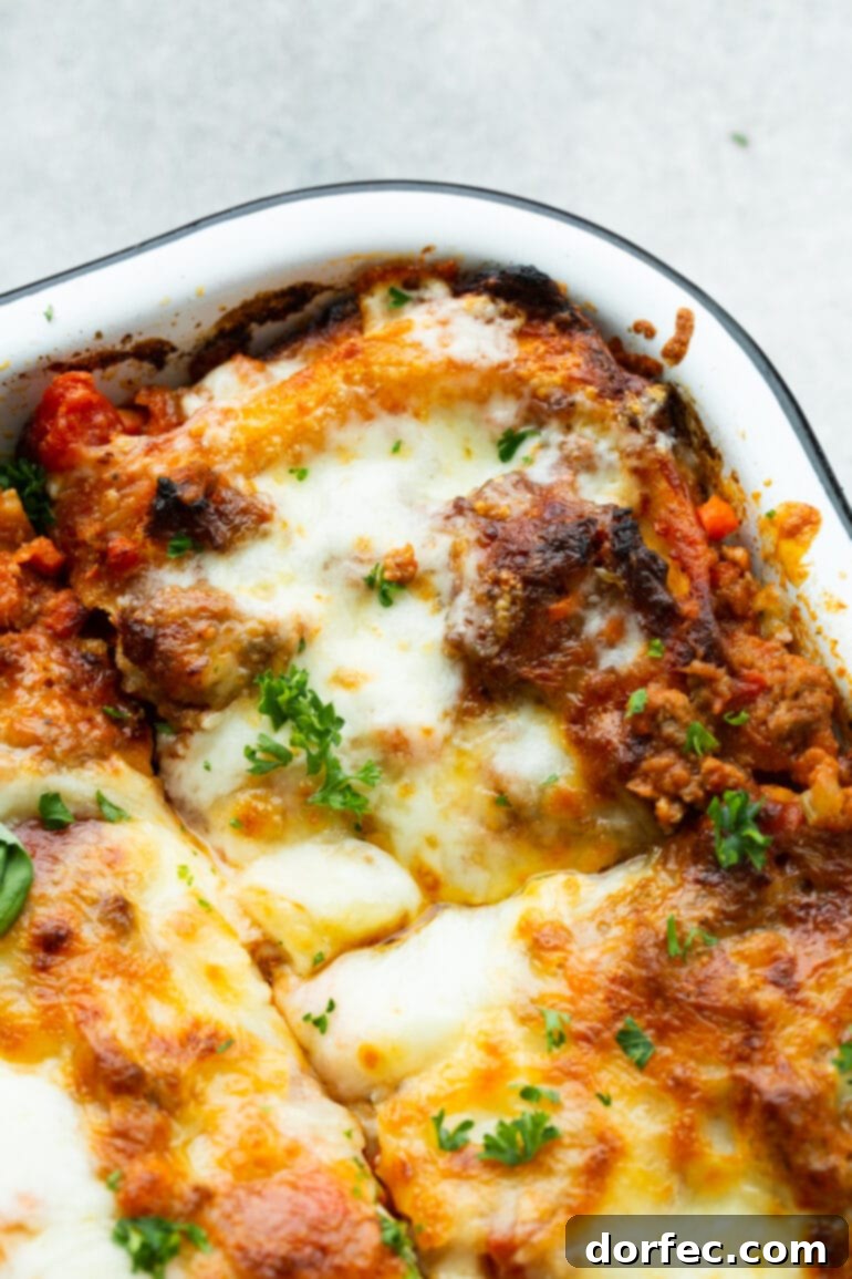 a photo of the corner of a baking dish full of baked meat lasagna