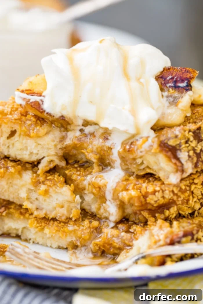 Cades Signature Bananas Foster French Toast 2 A towering stack of golden-brown Bananas Foster French Toast, generously drizzled with warm banana syrup and crowned with a dollop of fresh whipped cream. The French toast boasts a visible cornflake crust, promising a delightful crunch.