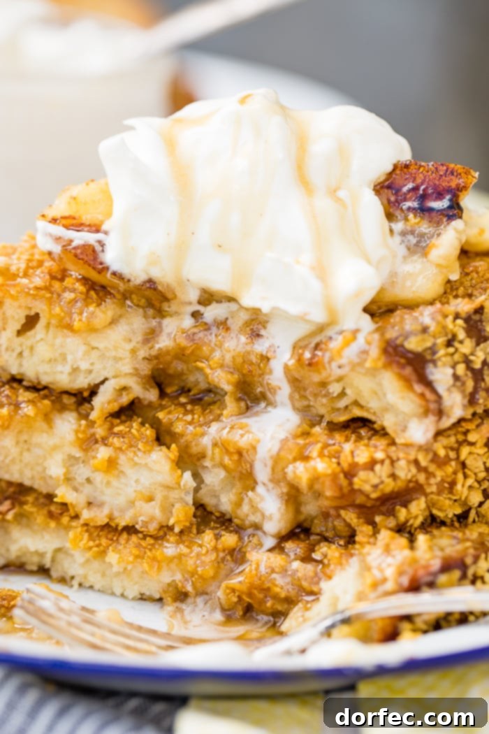 Cades Signature Bananas Foster French Toast 11 A scrumptious stack of fluffy French toast, showcasing its distinctive cornflake crust, rich Bananas Foster syrup, and a generous dollop of creamy whipped cream.