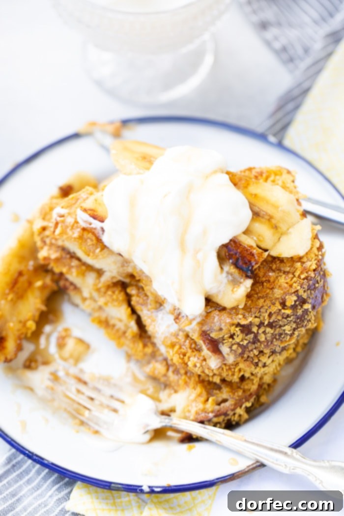 Cades Signature Bananas Foster French Toast 7 A beautifully presented stack of fluffy French toast with a crisp cornflake crust, bathed in luscious Bananas Foster syrup, and adorned with a generous swirl of whipped cream.