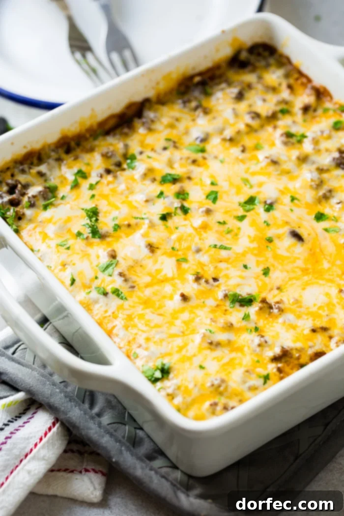 Cheesy Taco Rice and Beef Bake 4 A close-up of a white casserole dish filled with bubbling Mexican casserole, showing the rich texture.