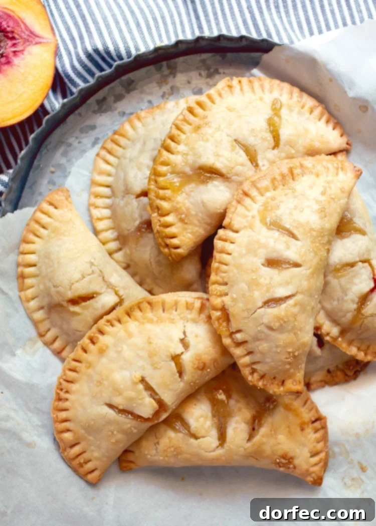 overhead view of pile of peach hand pie on metal tart pan
