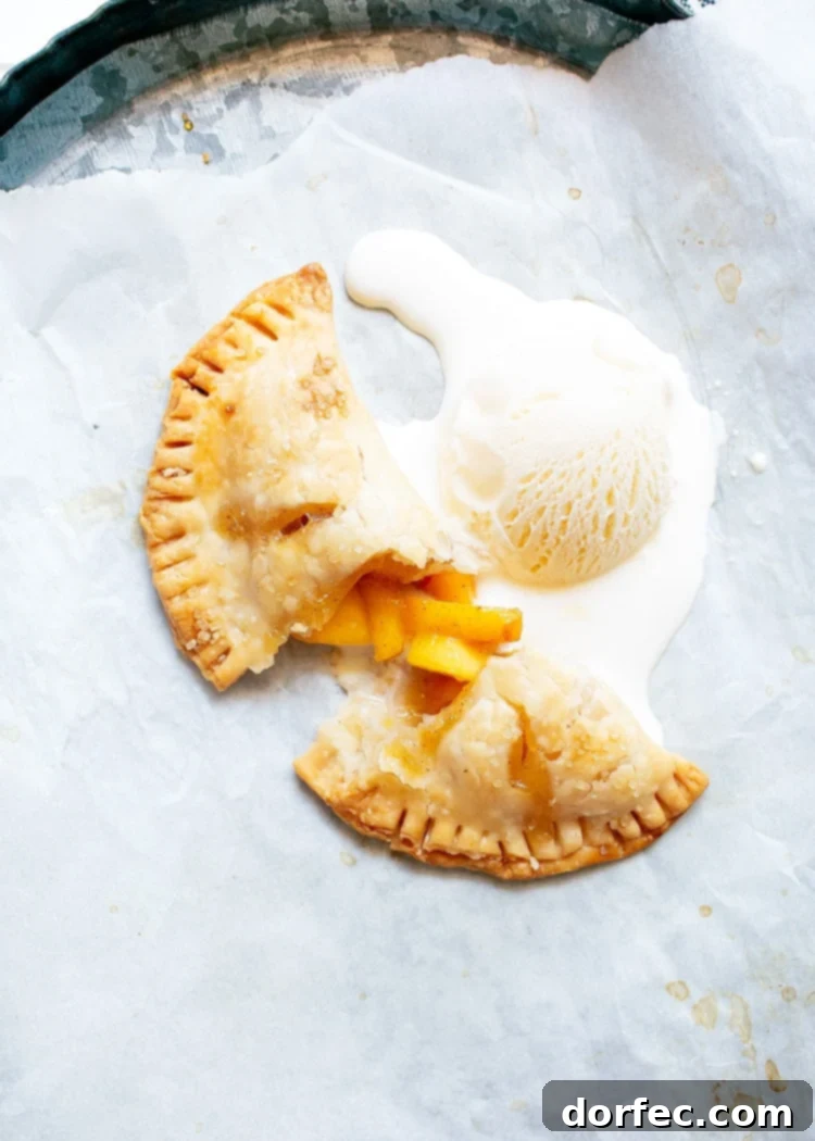 peach hand pie broken in half and topped with melting vanilla ice cream