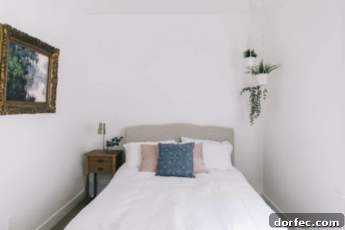 A wide shot of the guest bedroom, featuring a well-appointed bed and elegant window treatments.