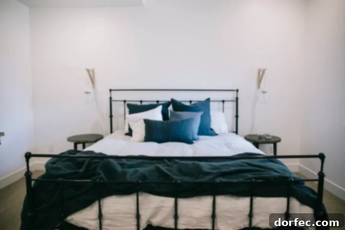 A stylish black iron bed frame paired with soft grey bedding, creating a modern and inviting look in the guest bedroom.
