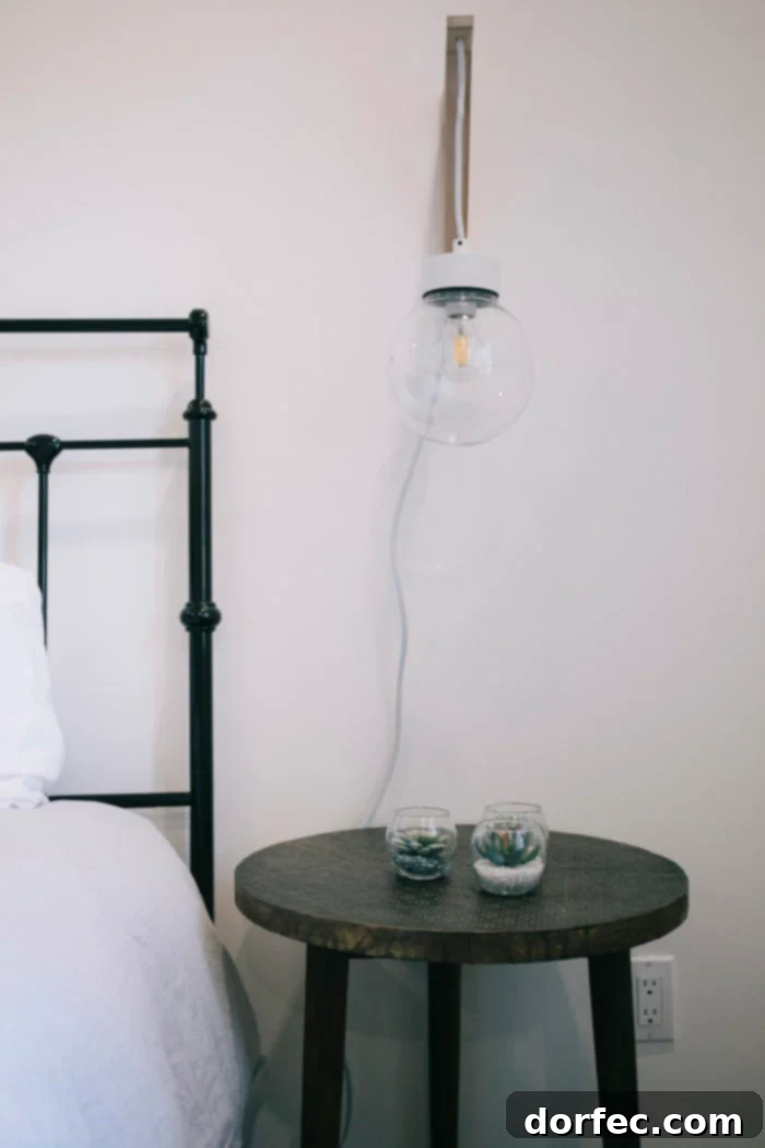 A stylish hanging globe pendant light elegantly suspended over a bedside table, providing soft illumination and a modern design accent in the bedroom.