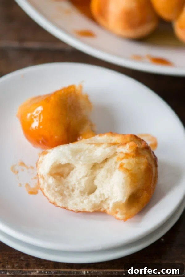 A close-up shot of Mom's Sticky Buns, showcasing their soft texture and rich, buttery glaze. A perfect holiday breakfast.