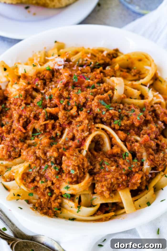 A white pasta dish full of fettuccini loaded with authentic Italian Bolognese sauce 