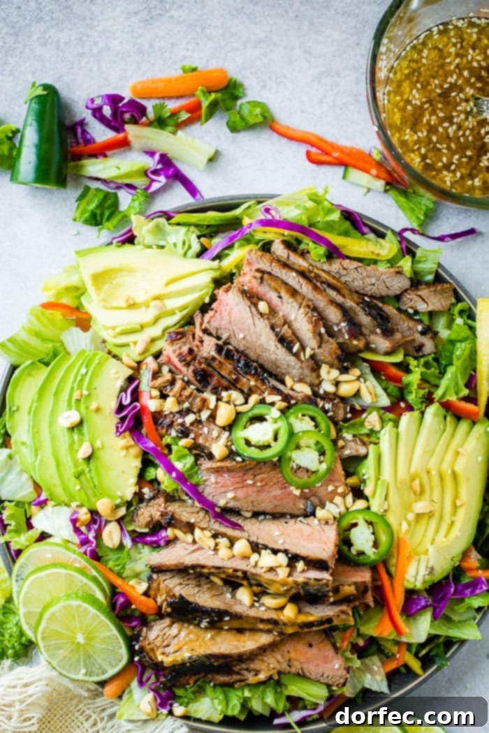 Zesty Thai Peanut Salad with Grilled Flank Steak 5 A colorful and inviting bowl of Healthy Thai Peanut Salad with Grilled Flank Steak, featuring mixed greens, freshly chopped vegetables, and tender, peanut sauce-marinated steak. A zesty ginger dressing, topped with sesame seeds, completes this delicious creation.