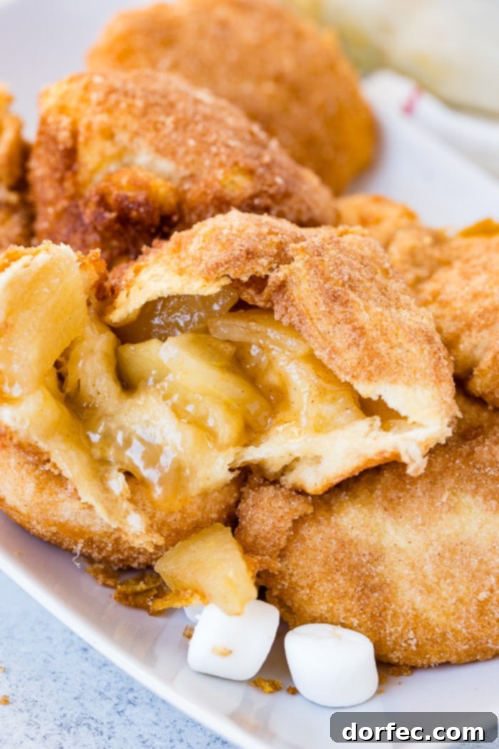 A close-up of a warm Apple Empty Tomb Roll, revealing its soft, fluffy interior and the luscious caramel sauce.