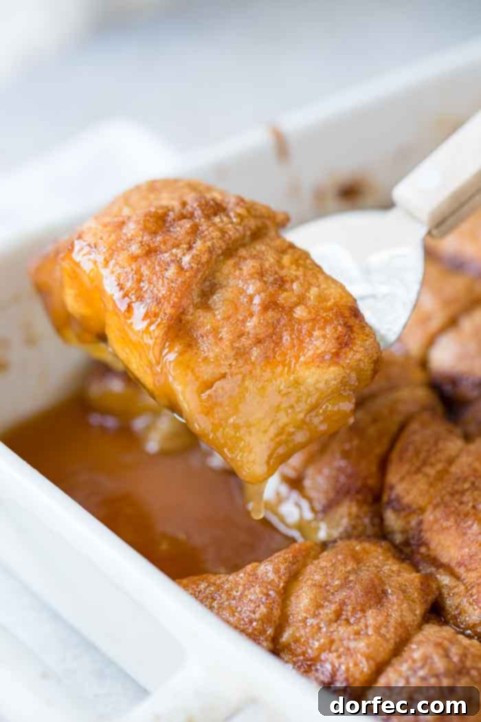 Sweet Simple Sprite Apple Dumplings 5 Another view of a white ceramic casserole dish brimming with perfectly baked apple dumplings, their golden crusts glistening with caramelized sauce.