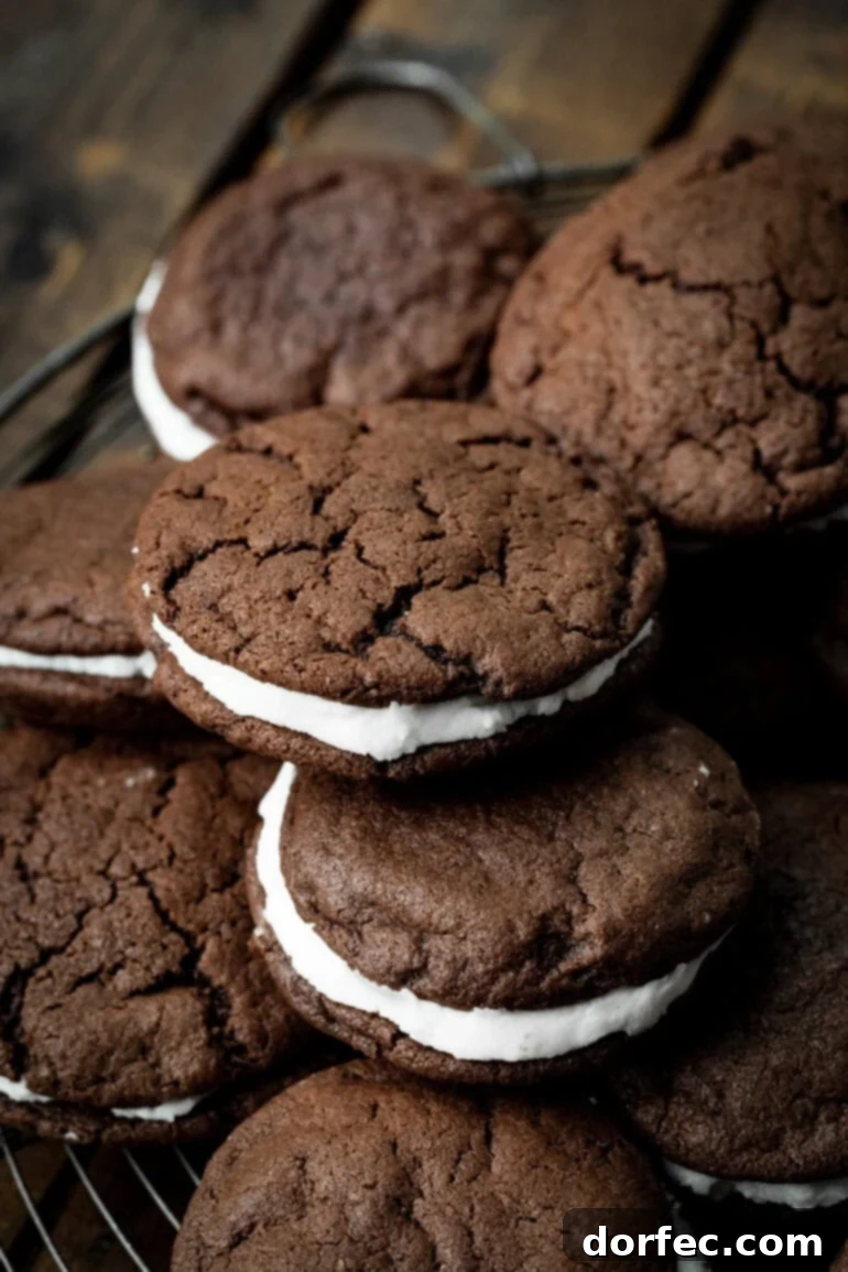 A photo of several homemade Oreo cookies piled on each other sitting on a circular wire cooling rack, ready to be enjoyed.
