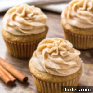 Three spice cake cupcakes topped with cinnamon cream cheese buttercream.