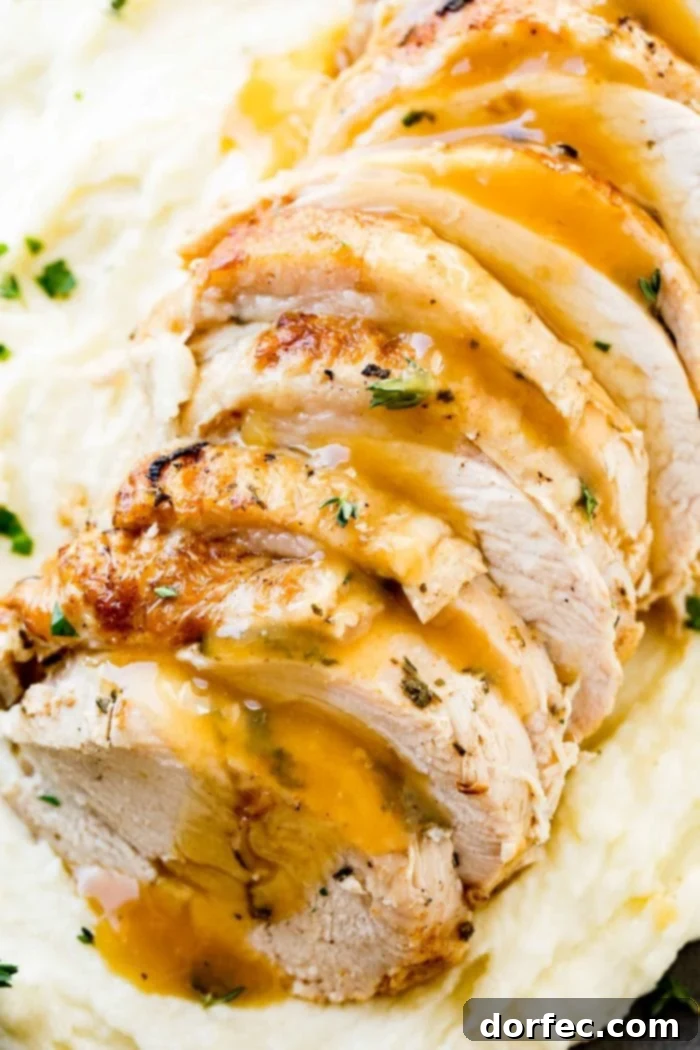 A close-up photograph of a succulent Instant Pot turkey breast, beautifully sliced and topped with a luscious gravy, garnished with vibrant fresh herbs, served alongside creamy mashed potatoes.