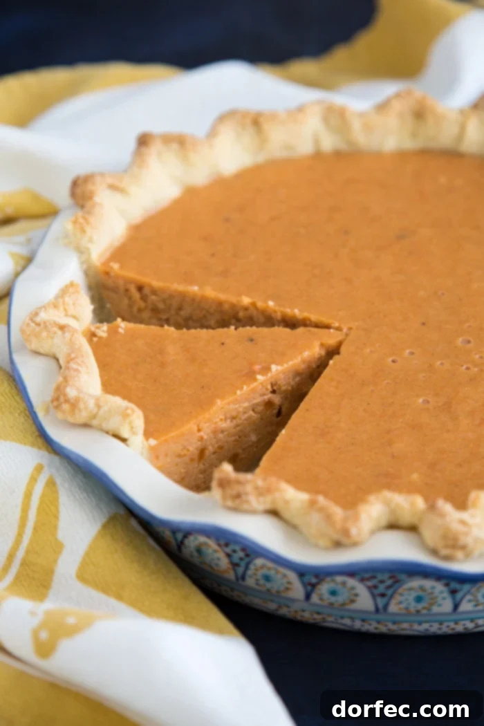 A beautifully baked sweet potato pie, showcasing its golden-brown crust and smooth, inviting filling, ready for slicing.