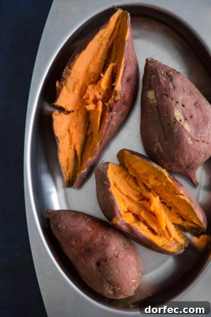 Perfectly roasted sweet potatoes, golden and tender, ready to be mashed for the creamy sweet potato pie filling.