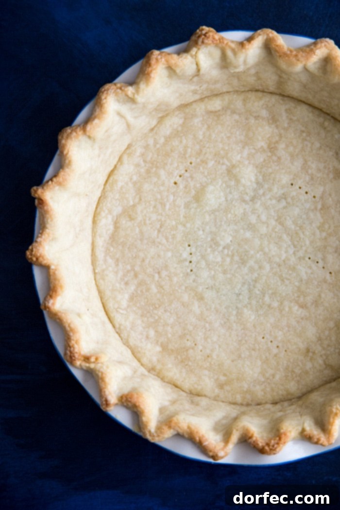 A perfectly par-baked pie crust, golden and sturdy, ready to receive the rich sweet potato cheesecake filling.