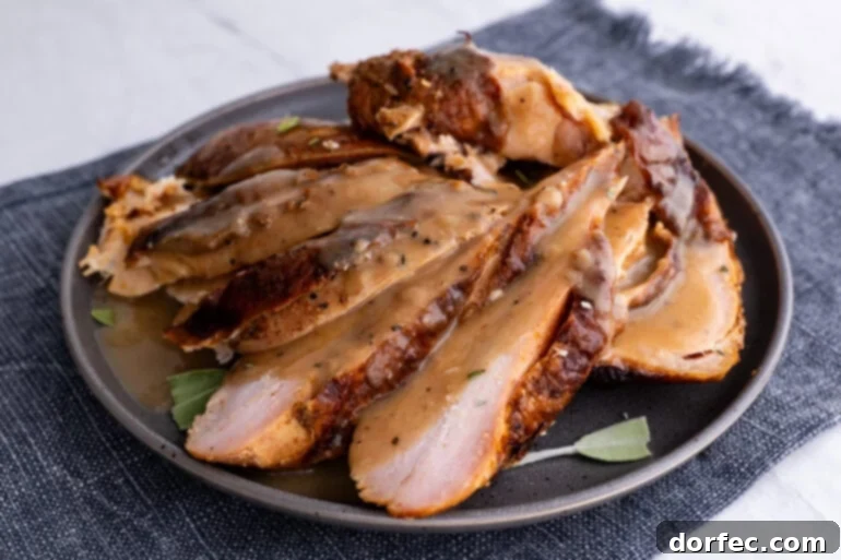 A close-up of beautifully sliced smoked turkey breast arranged on a dark gray plate, inviting a taste.
