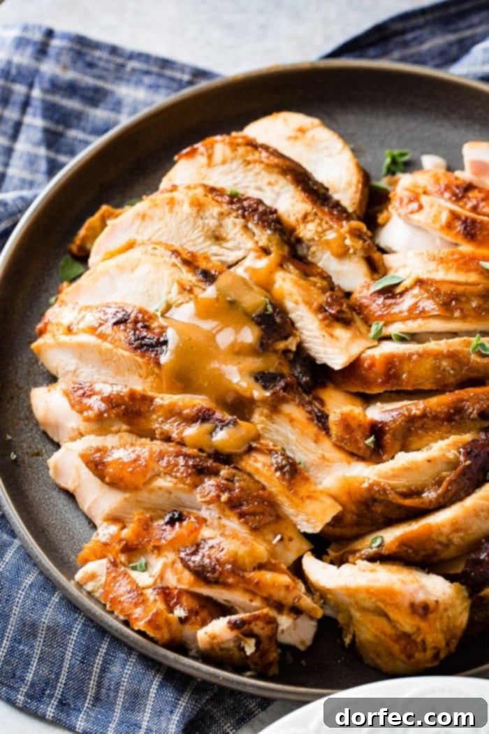 A grey plate featuring sliced smoked turkey breast, artfully garnished with fresh thyme, ready for serving.