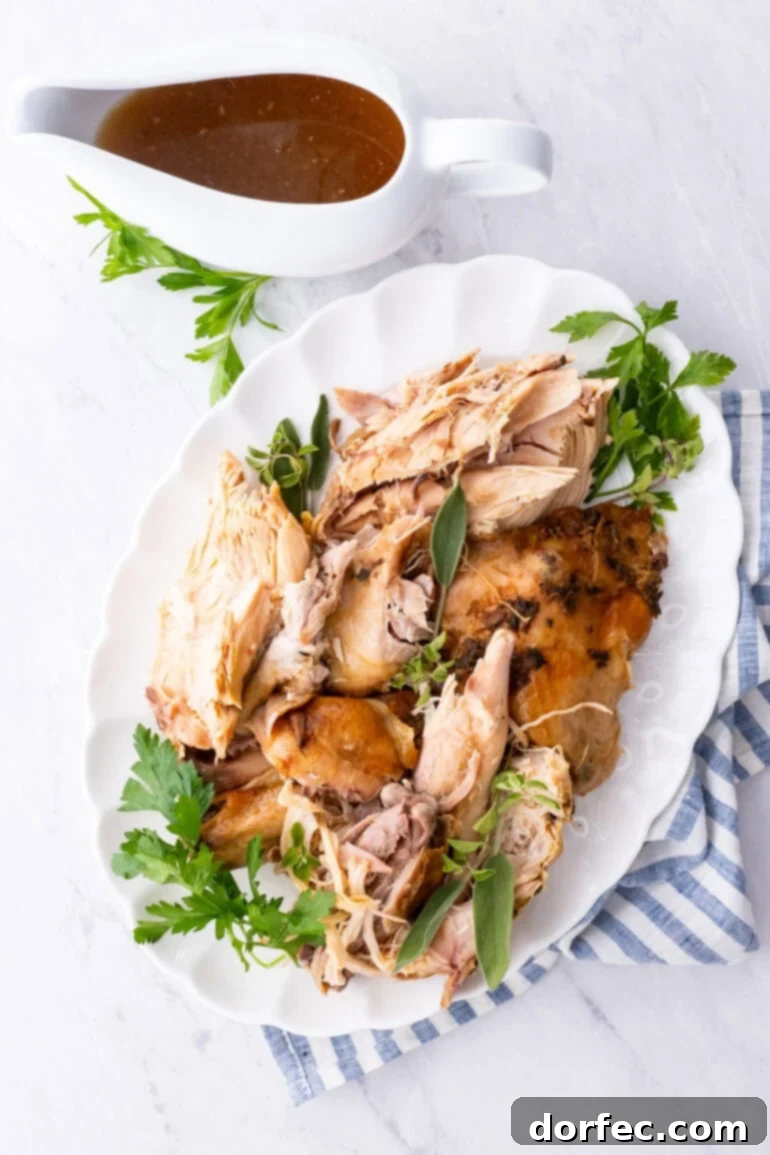 A beautifully golden-brown, sliced turkey presented on a large oval platter, with a side of homemade gravy. The turkey looks incredibly tender and succulent.