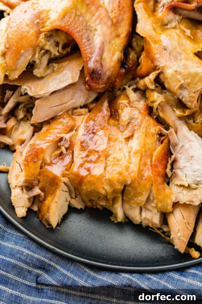 A grey platter displaying succulent, shredded turkey, a testament to the tenderness achieved by cooking in a bowl.
