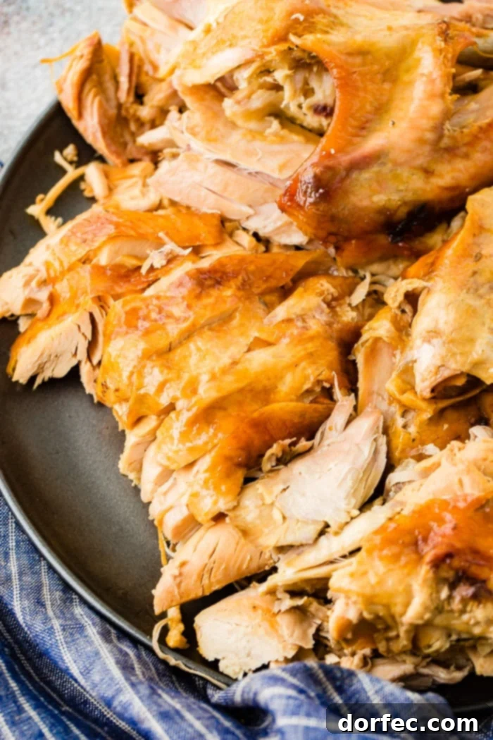 A grey platter laden with succulent, shredded turkey, a perfect example of the tender results from cooking it in a bowl.