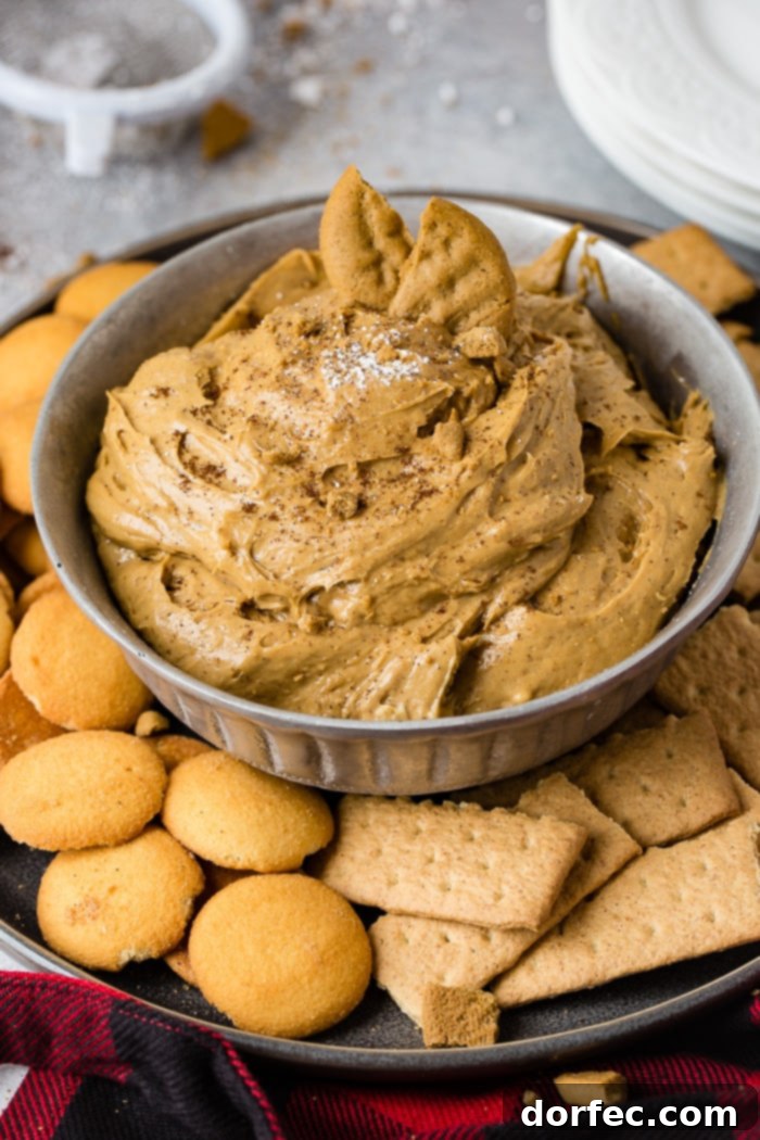 Festive Gingerbread Cookie Dip 5 a silver bowl full of fluffy gingerbread cookie dip or molasses cookie dip with graham crackers and nilla wafers