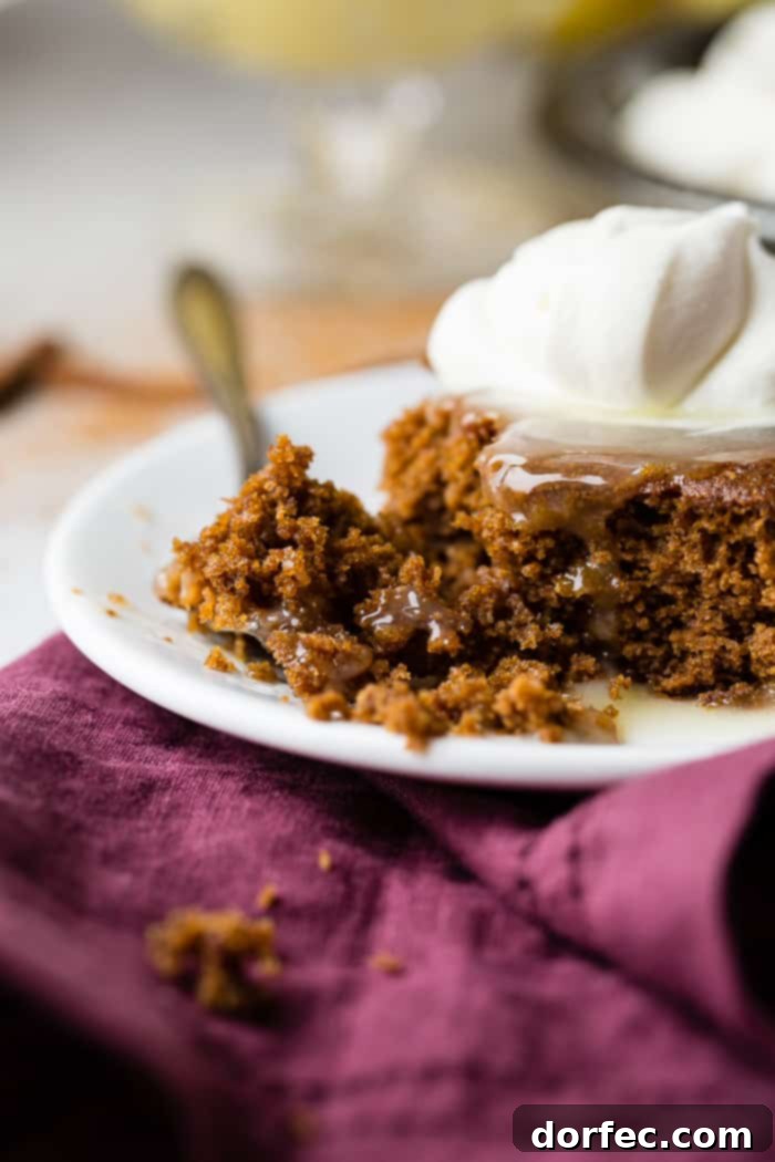 Spiced Gingerbread Cake with Zesty Lemon Glaze 3 a warm slice of gingerbread cake with lemon sauce and a dollop of whipped cream