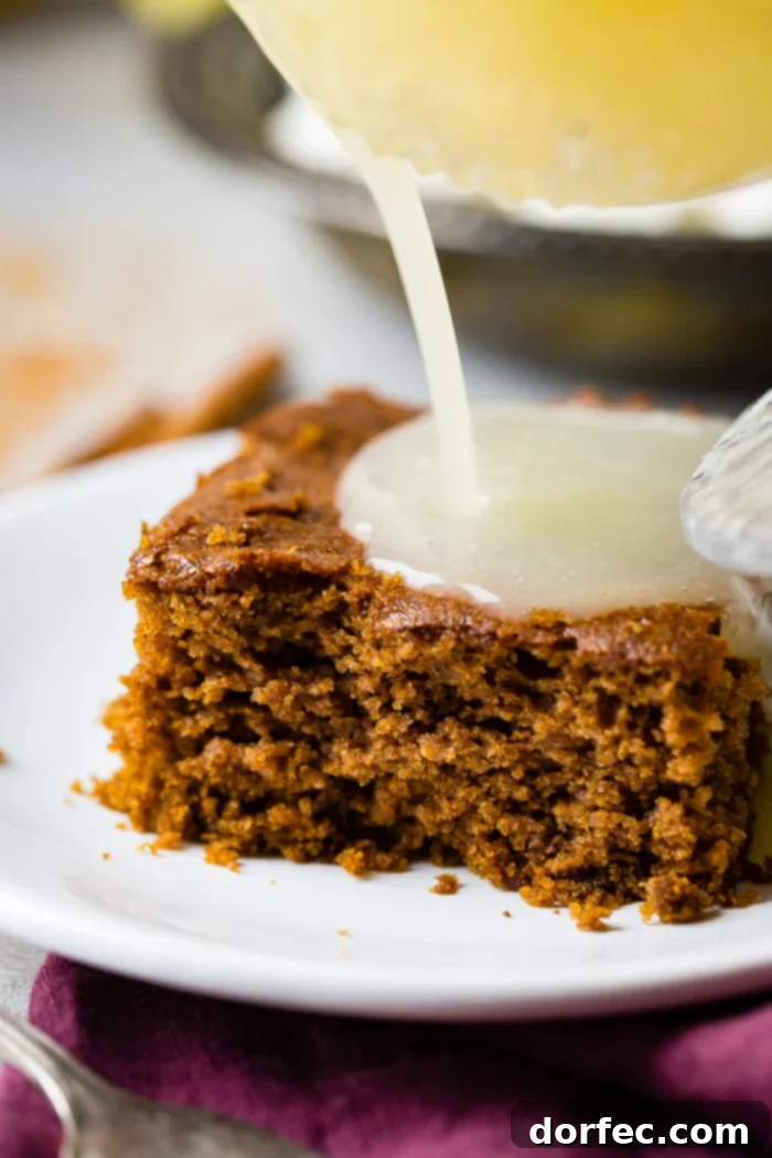 Spiced Gingerbread Cake with Zesty Lemon Glaze 4 a warm slice of gingerbread cake with lemon sauce and a dollop of whipped cream