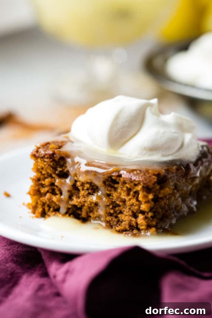 Spiced Gingerbread Cake with Zesty Lemon Glaze 5 a warm slice of gingerbread cake with lemon sauce and a dollop of whipped cream