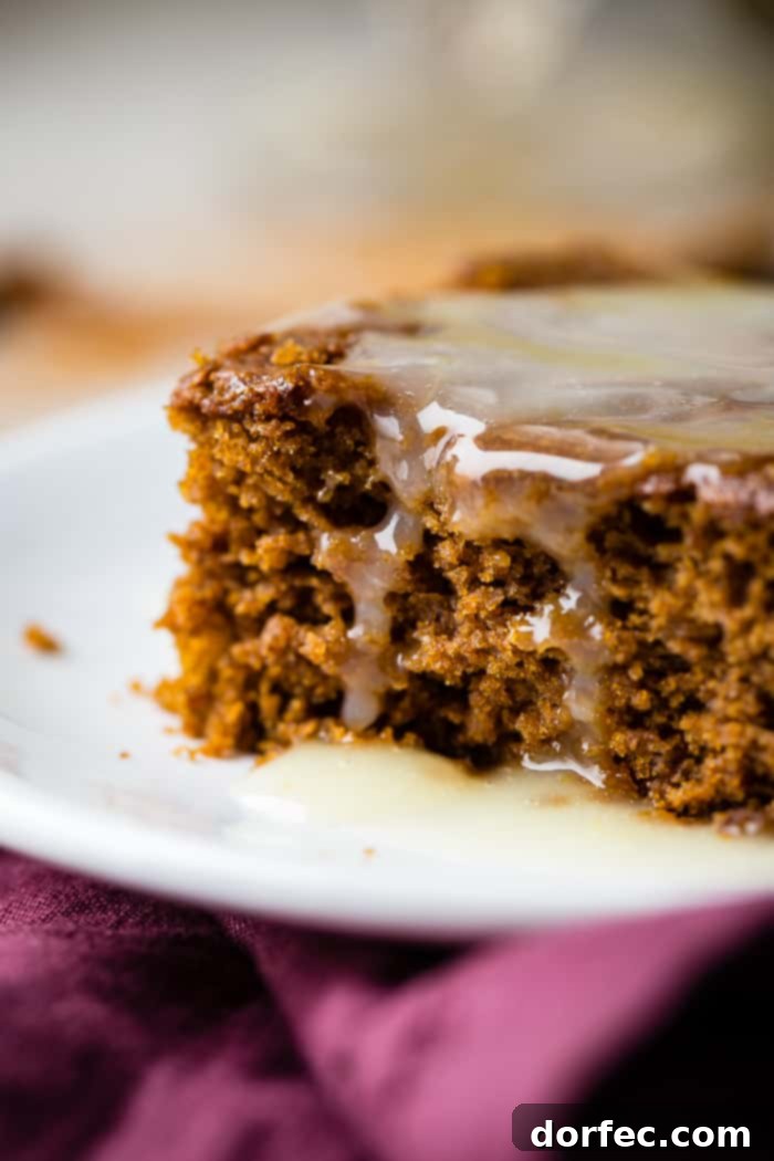 Spiced Gingerbread Cake with Zesty Lemon Glaze 6 a warm slice of gingerbread cake with lemon sauce and a dollop of whipped cream