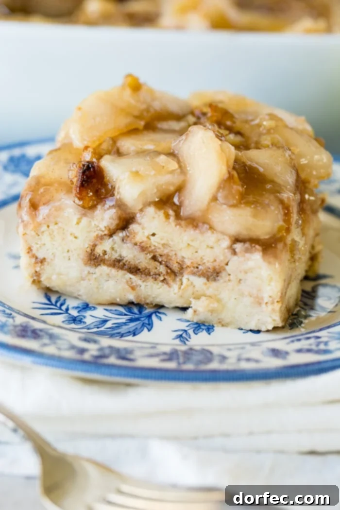 Irresistible Apple Pie Bread Pudding with Silky Vanilla Sauce 4 A close-up shot of an easy bread pudding slice with a bite taken out, showing its soft interior and the glistening vanilla sauce.