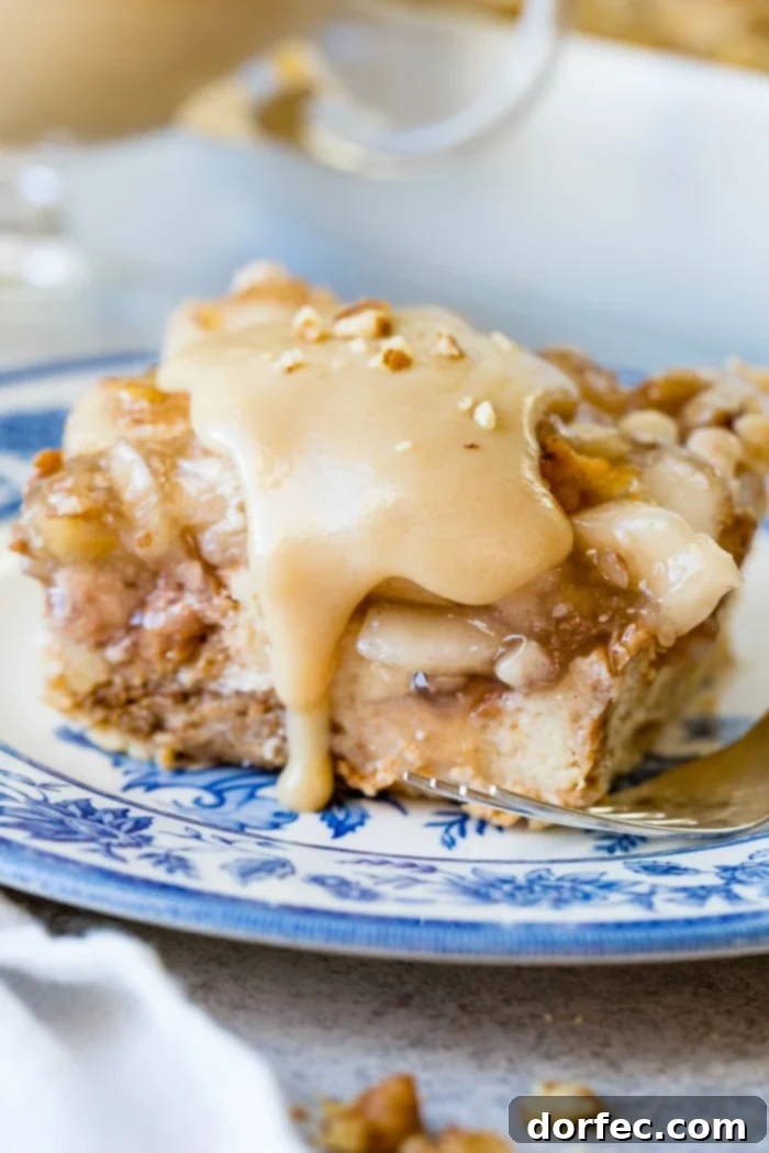 Irresistible Apple Pie Bread Pudding with Silky Vanilla Sauce 7 Another mouthwatering close-up of apple pie bread pudding with a bite taken, emphasizing its perfect golden crust and saucy goodness.
