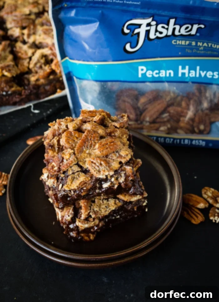 A close-up of a single pecan pie brownie square, showcasing its texture.