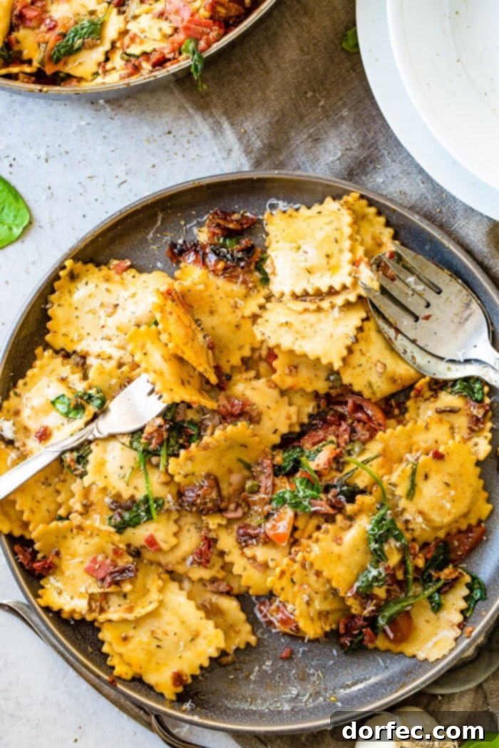 A serving of Easy Crispy Pancetta Ravioli with Sun-Dried Tomatoes and Spinach, garnished with fresh Parmesan cheese.
