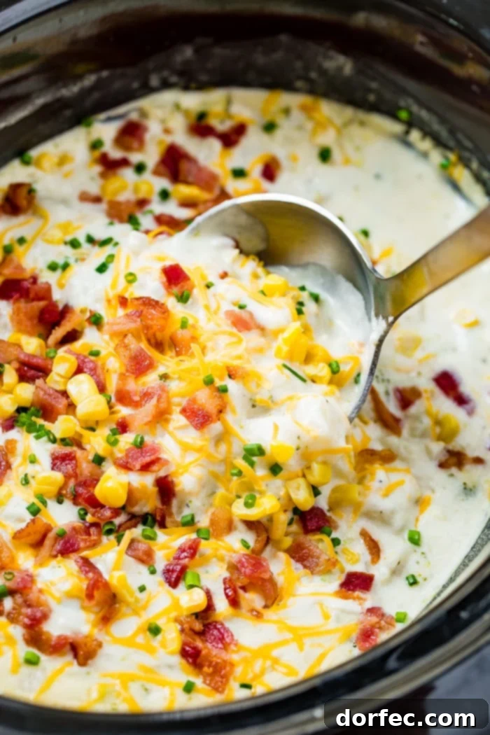 A close-up shot of a white bowl filled with slow cooker potato broccoli corn chowder with bacon, ready to be enjoyed.
