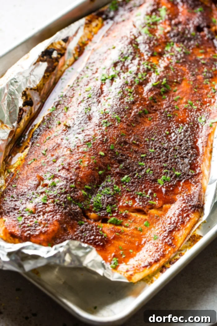 Fork taking a bite of healthy maple glazed salmon baked in foil
