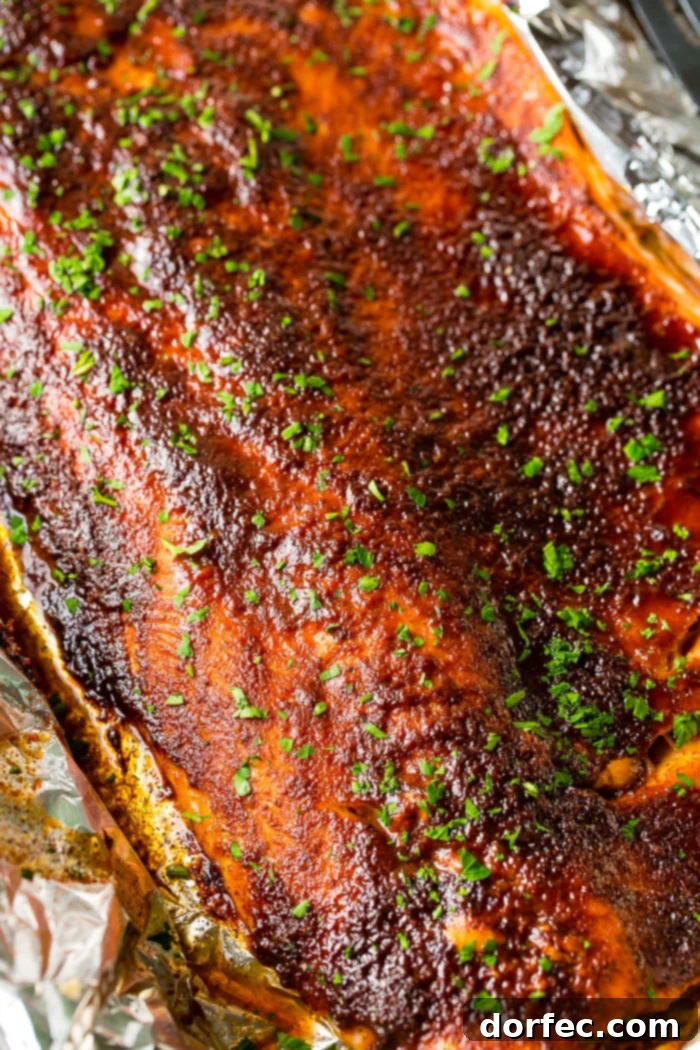 Close-up of maple syrup salmon in foil with a fork taking a bite