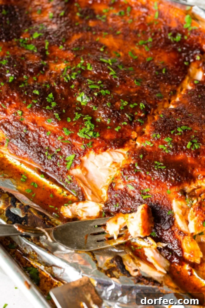 Baked glazed salmon in foil with a fork resting on the side, ready to be served