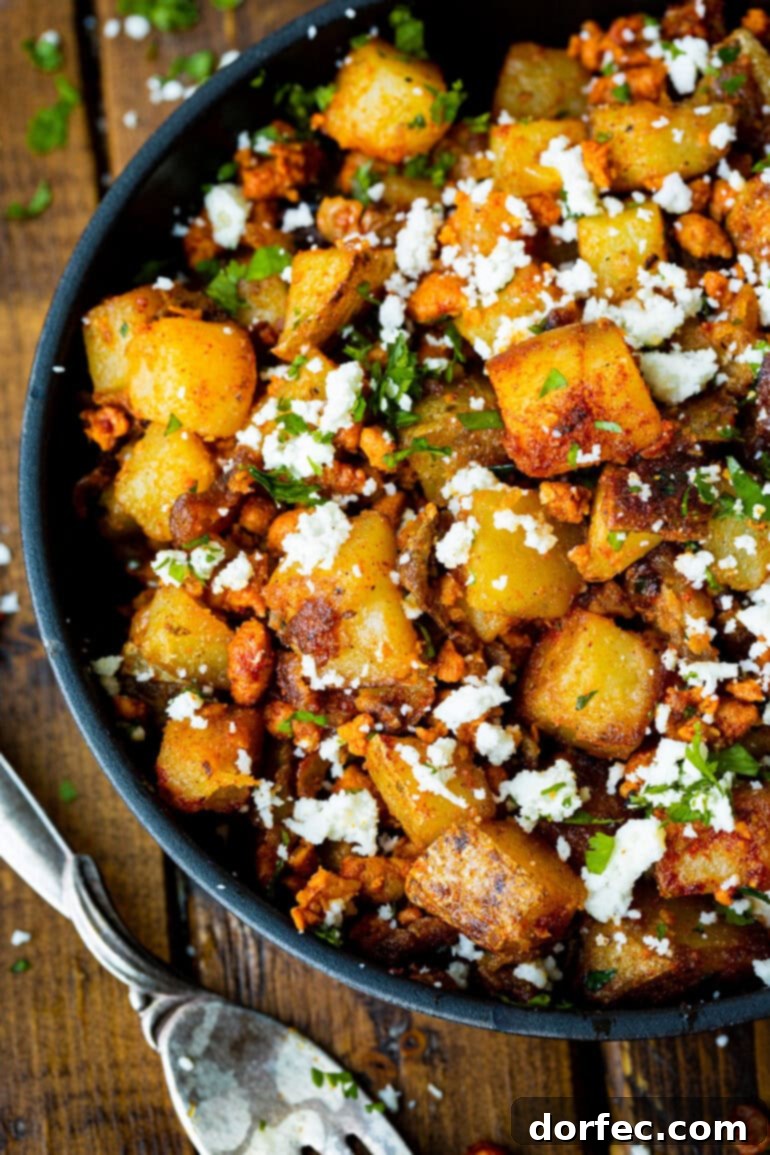 Quick Chorizo and Potato Hash 2 A large serving dish filled with golden, crispy cubed potatoes mixed with spicy chorizo, fresh cilantro, and crumbled cotija cheese, ready to be served for an authentic Mexican breakfast or side dish.