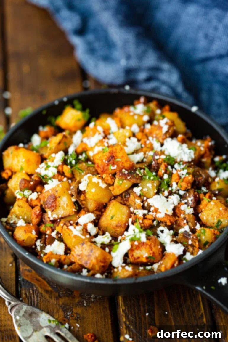 Quick Chorizo and Potato Hash 3 A large serving bowl filled with golden crispy potato chunks perfectly mixed with savory chorizo, fresh cotija cheese, and vibrant chopped cilantro, ideal for a hearty breakfast or brunch.