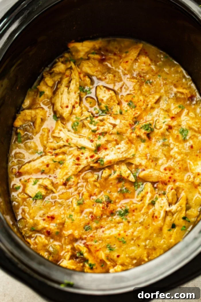 Sweet and Savory Pineapple Mexican Shredded Chicken Instant Pot or Slow Cooker 2 A slow cooker brimming with vibrant shredded chicken in a rich salsa verde pineapple sauce, ready to be served