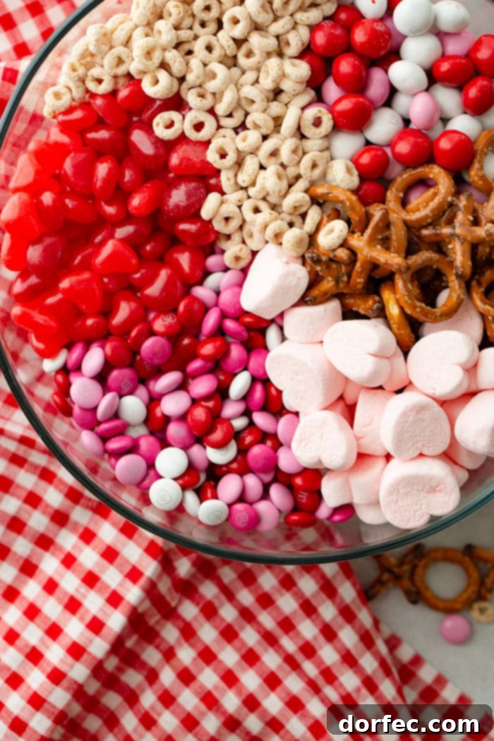 A beautifully arranged glass bowl of Valentine's Snack Mix with a red and white checkered napkin, perfect for a festive treat.