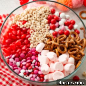 A vibrant overhead shot of the 5-Minute Valentine's Snack Mix, showcasing all its delightful components in a clear glass bowl, perfect for a quick and easy holiday treat.