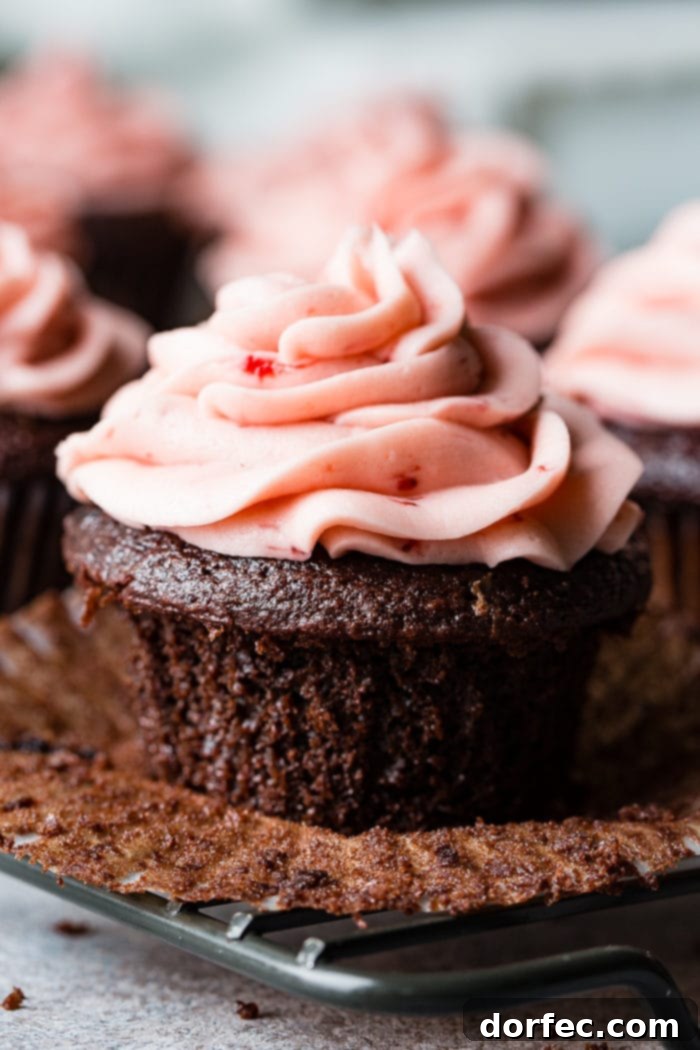 Choco-Berry Nutella Bliss Cupcakes 5 A delicious Nutella Stuffed Strawberry Chocolate Cupcake, topped with a swirl of pink buttercream and a fresh strawberry. The cupcake is cut in half, revealing its gooey Nutella center.