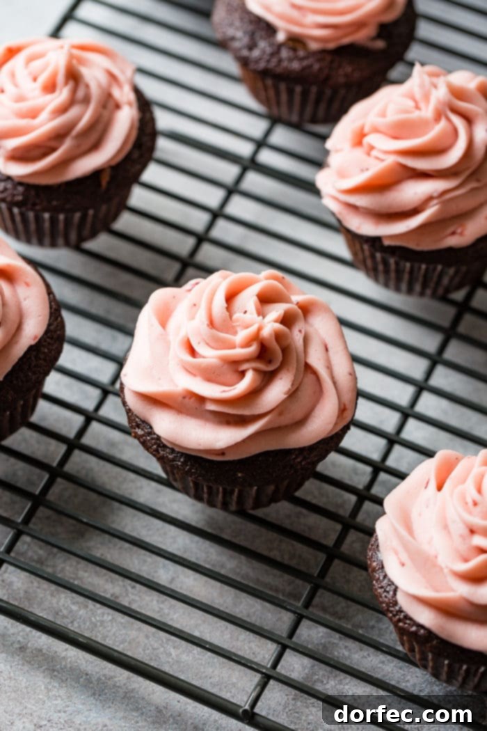 Choco-Berry Nutella Bliss Cupcakes 7 An inviting spread of Nutella Stuffed Strawberry Chocolate Cupcakes, each featuring a perfect swirl of pink strawberry buttercream and a fresh strawberry garnish.