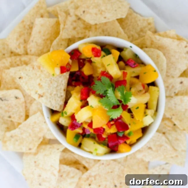 Delicious Peach Pineapple Salsa in a bowl with fresh ingredients