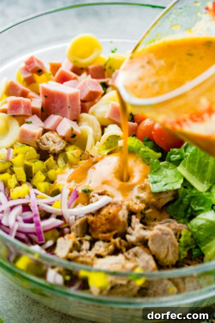 A photo of dressing being poured on a cuban pasta salad.
