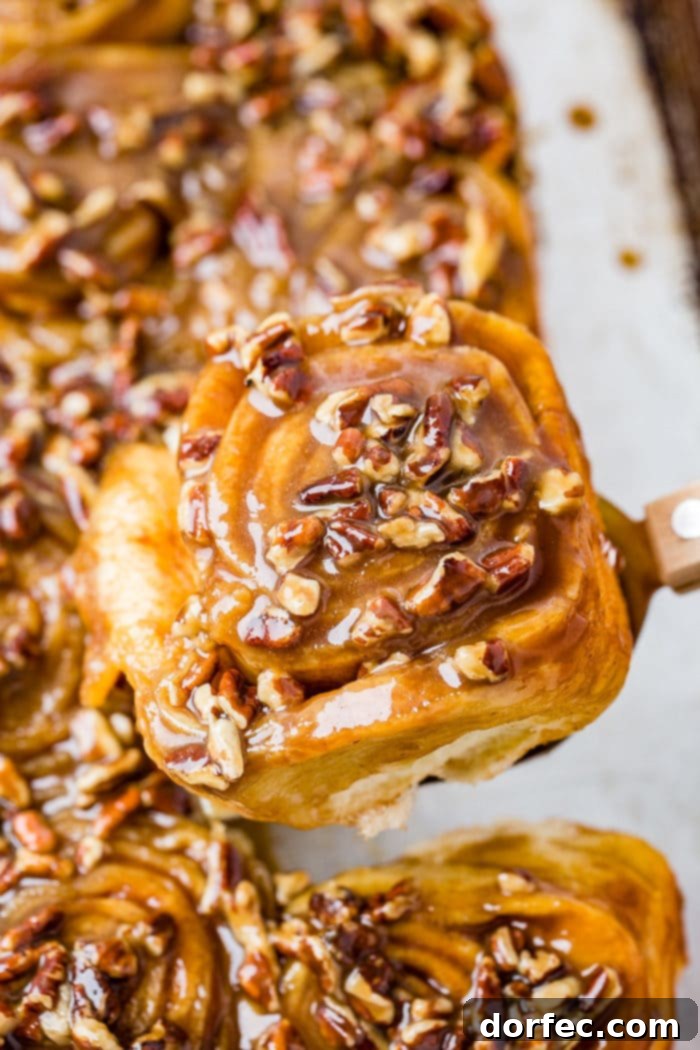 Caramel Pecan Sticky Buns 7 A photo of a sticky bun taking from above covered in a caramel glaze and chopped pecans.