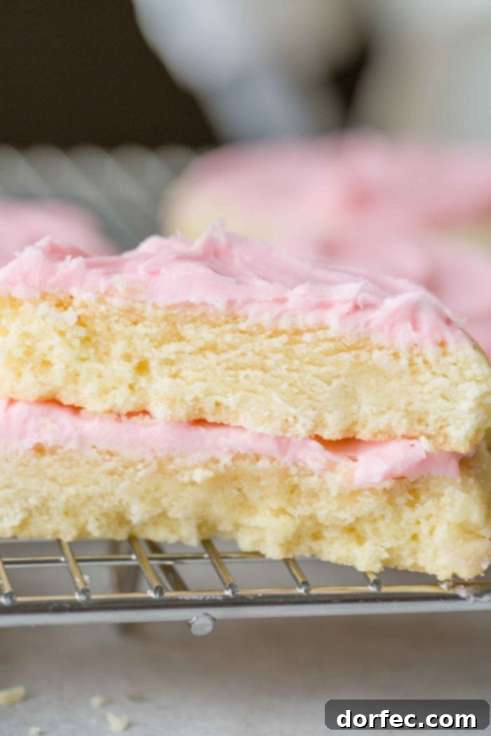 Copycat Swig Sugar Cookies and Signature Frosting 5 A cross-section view of two thick Swig Sugar Cookies with pink frosting, stacked to show their incredibly soft and tender interior.